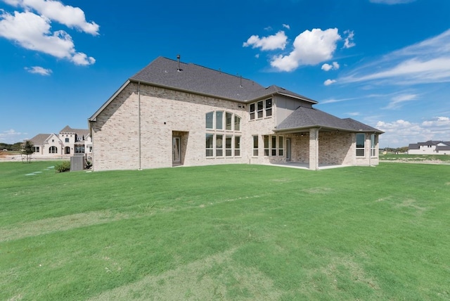 back of property with a lawn and central air condition unit