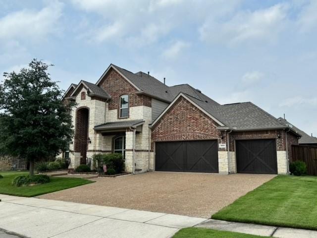 view of front of property featuring brick siding, a shingled roof, concrete driveway, an attached garage, and a front yard