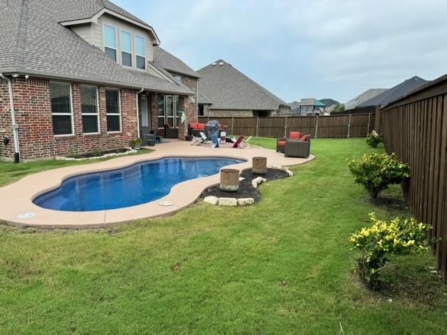 view of pool featuring a fenced in pool, a fenced backyard, a yard, and a patio