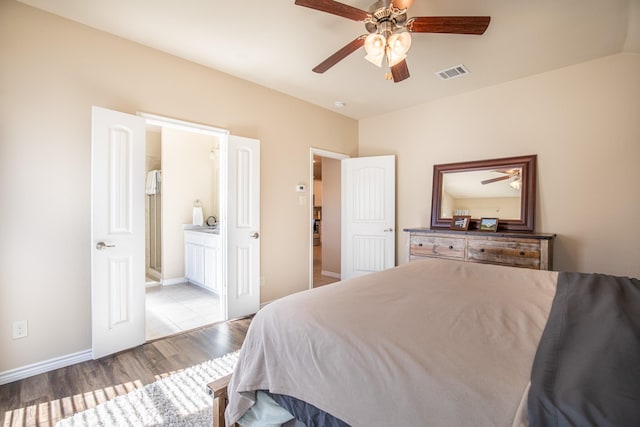 bedroom featuring light hardwood / wood-style floors, ceiling fan, and ensuite bathroom