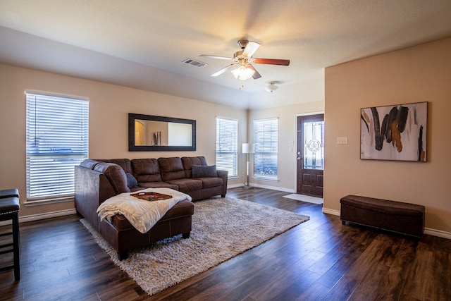 living room featuring a healthy amount of sunlight, dark wood-type flooring, and ceiling fan