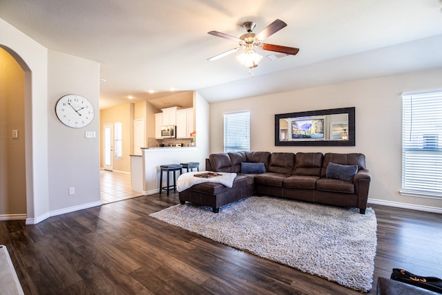 living room featuring ceiling fan, vaulted ceiling, a healthy amount of sunlight, and dark hardwood / wood-style floors