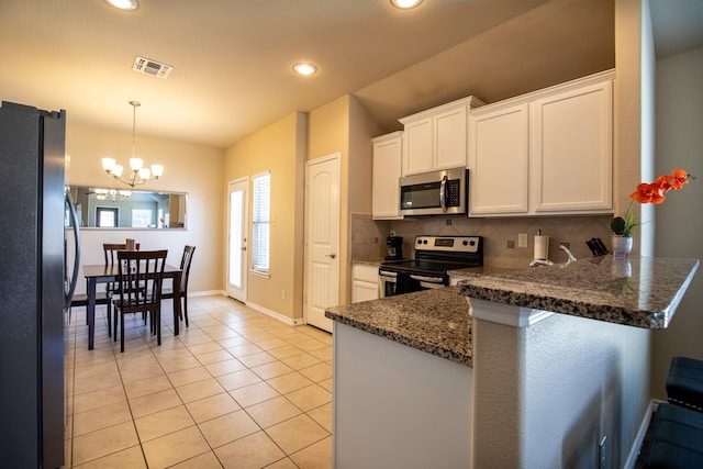 kitchen with tasteful backsplash, white cabinetry, hanging light fixtures, light tile patterned floors, and stainless steel appliances