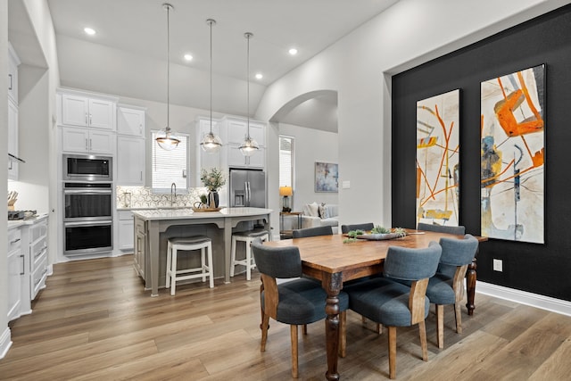 dining area featuring ceiling fan, sink, and light hardwood / wood-style floors