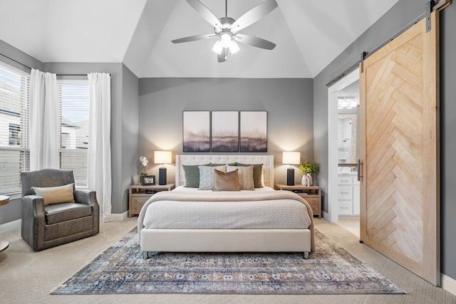 carpeted bedroom featuring ceiling fan, a barn door, lofted ceiling, and ensuite bath