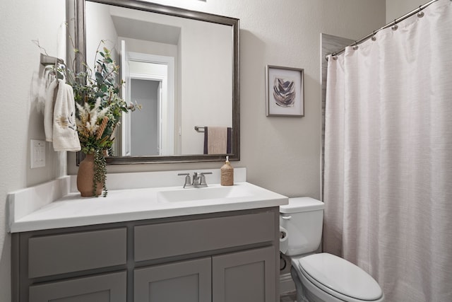 bathroom featuring vanity, toilet, and walk in shower