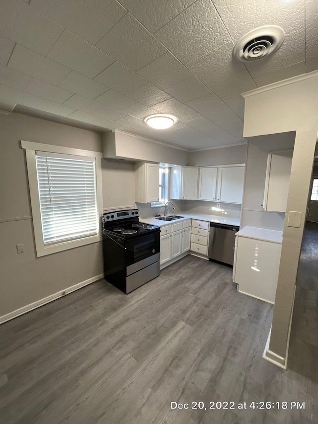 kitchen with sink, stainless steel dishwasher, range with electric cooktop, light hardwood / wood-style floors, and white cabinets