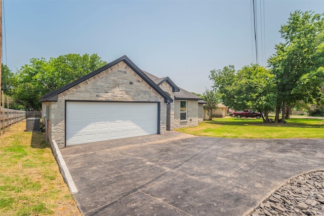 view of front of property with a garage, a front lawn, and central air condition unit