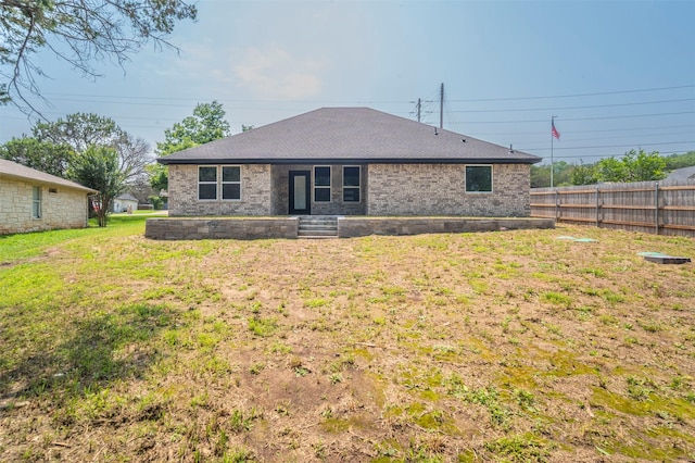 rear view of property featuring a lawn