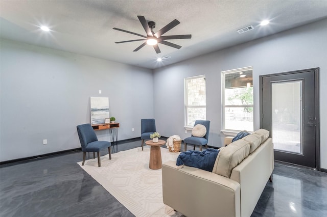 living room with a textured ceiling and ceiling fan