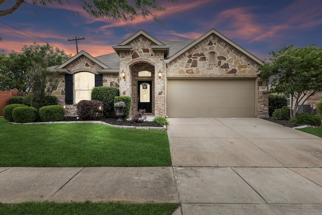 view of front of property featuring a garage and a lawn