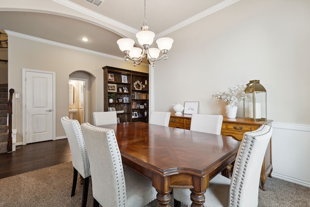 dining room featuring crown molding, dark hardwood / wood-style floors, and an inviting chandelier