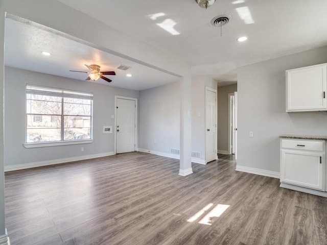 unfurnished living room featuring ceiling fan and light wood-type flooring