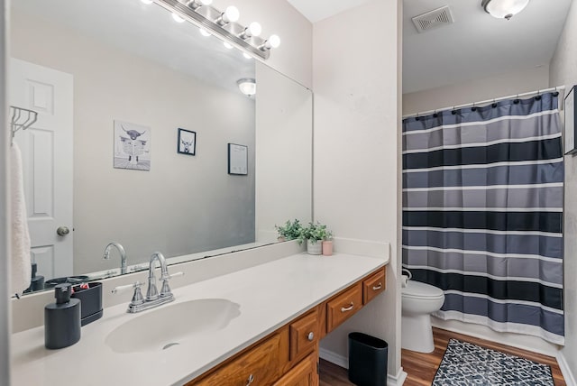 bathroom with vanity, wood-type flooring, a shower with shower curtain, and toilet