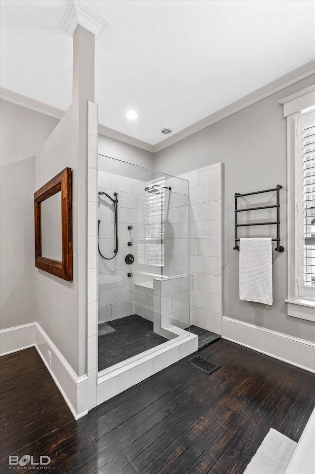 bathroom featuring crown molding, wood-type flooring, and a tile shower