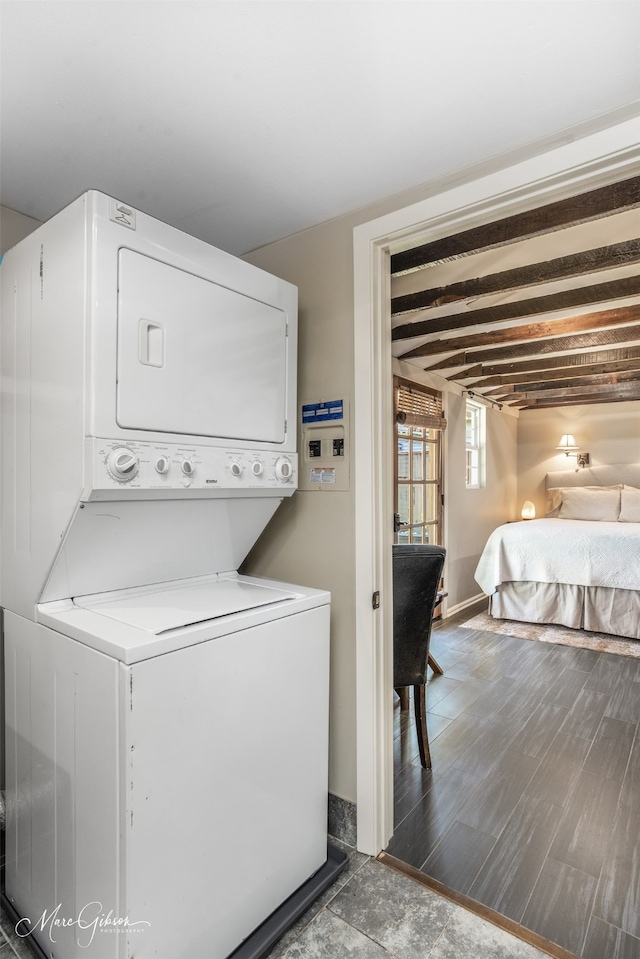 washroom with stacked washer and dryer and dark wood-type flooring