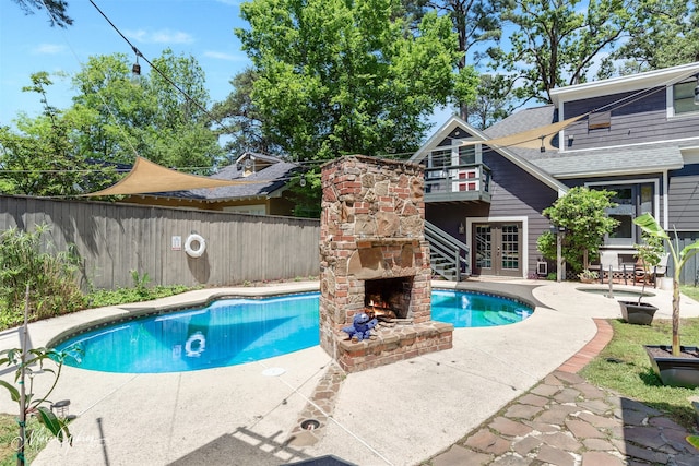 view of pool featuring an outdoor stone fireplace and a patio area