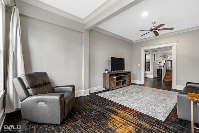 living room with dark wood-type flooring, ceiling fan, and crown molding