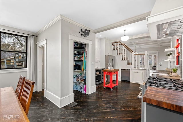 kitchen with appliances with stainless steel finishes, dark hardwood / wood-style floors, decorative light fixtures, sink, and white cabinets