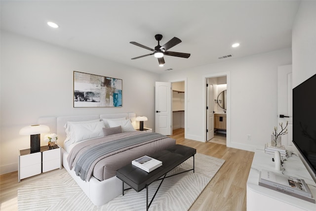 bedroom with ceiling fan, a spacious closet, light hardwood / wood-style floors, and a closet