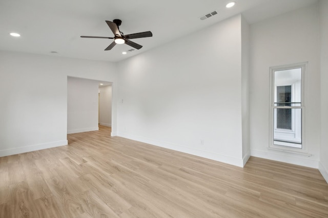 spare room with ceiling fan, lofted ceiling, and light wood-type flooring