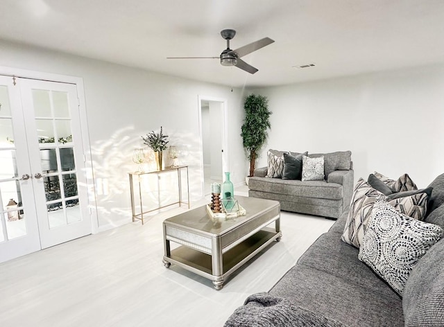 living room with wood-type flooring, ceiling fan, and french doors