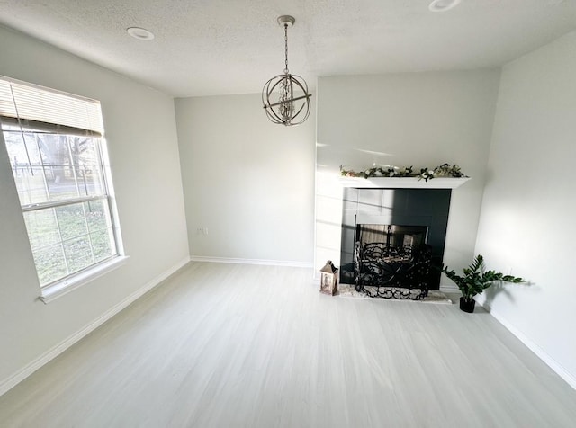 living room featuring hardwood / wood-style flooring, a chandelier, and a textured ceiling