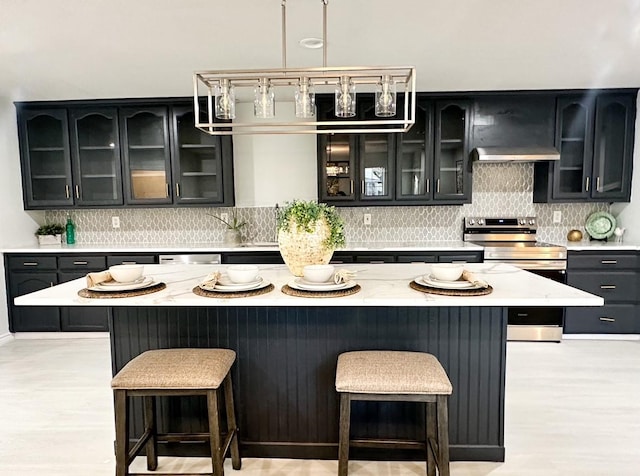 kitchen featuring backsplash, a kitchen island, premium range hood, and appliances with stainless steel finishes