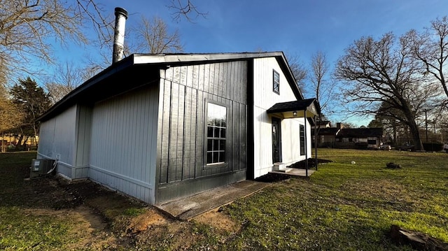 view of property exterior featuring central AC unit and a lawn