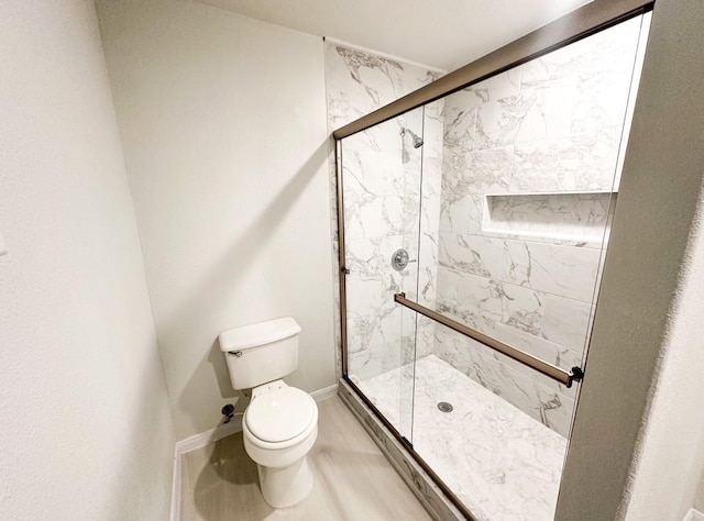 bathroom with an enclosed shower and toilet