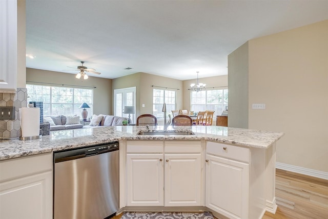 kitchen featuring dishwasher, white cabinets, decorative backsplash, light hardwood / wood-style floors, and kitchen peninsula