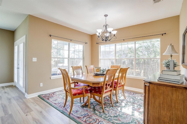 dining area with an inviting chandelier and light hardwood / wood-style floors