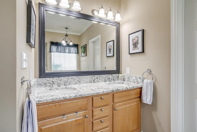 bathroom featuring vanity, ornamental molding, and an inviting chandelier