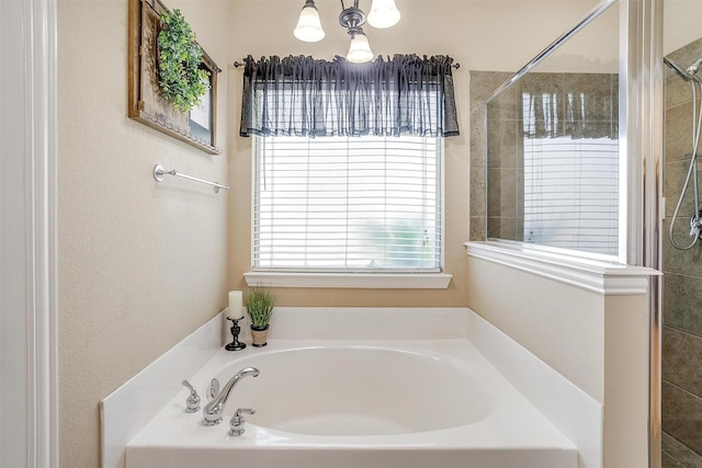 bathroom with an inviting chandelier and separate shower and tub