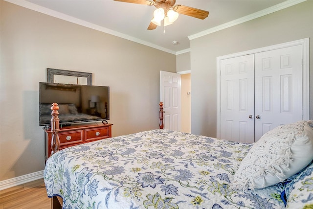 bedroom with wood-type flooring, ornamental molding, ceiling fan, and a closet