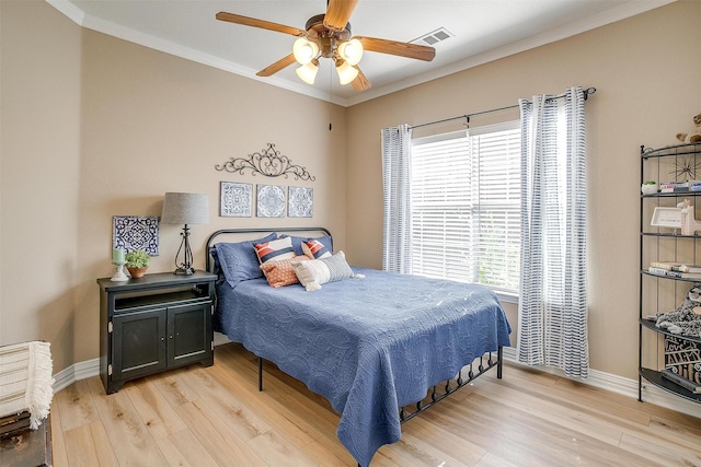 bedroom with ornamental molding, ceiling fan, and light hardwood / wood-style floors