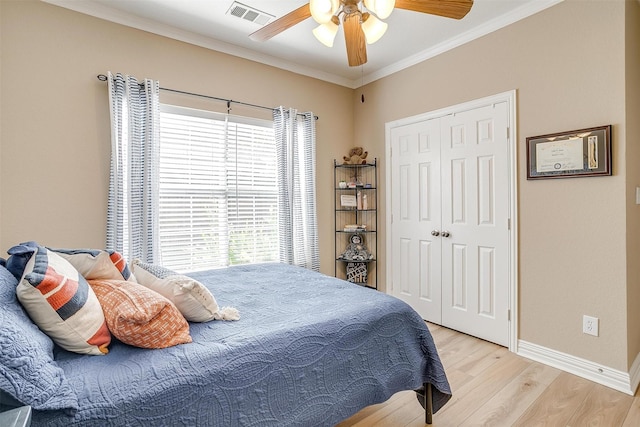 bedroom featuring crown molding, a closet, ceiling fan, and light hardwood / wood-style flooring