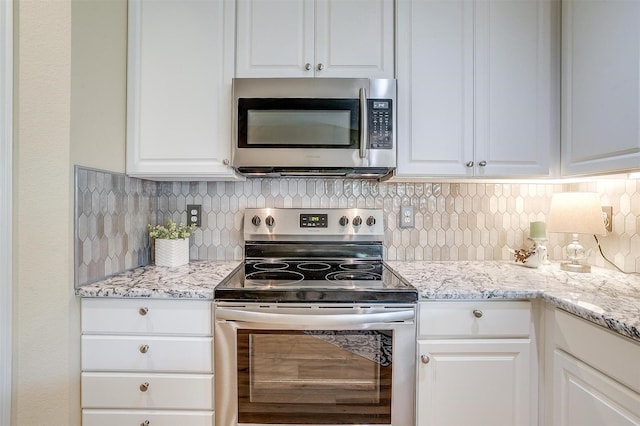 kitchen featuring white cabinetry, appliances with stainless steel finishes, light stone counters, and tasteful backsplash