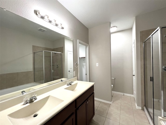 bathroom featuring tile patterned flooring, vanity, toilet, and walk in shower