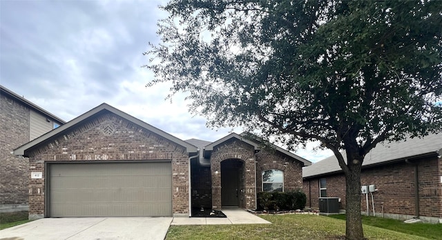 view of front of home featuring cooling unit, a garage, and a front lawn