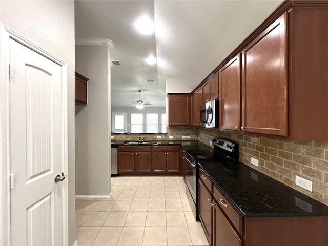 kitchen with light tile patterned flooring, sink, appliances with stainless steel finishes, dark stone counters, and backsplash