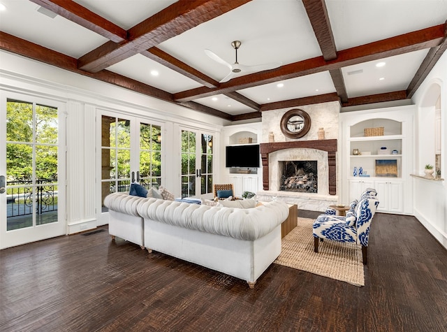 living room with dark hardwood / wood-style floors, coffered ceiling, a large fireplace, built in shelves, and french doors