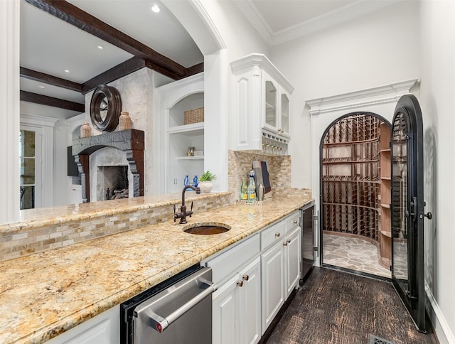 kitchen featuring white cabinetry, sink, stainless steel dishwasher, and backsplash