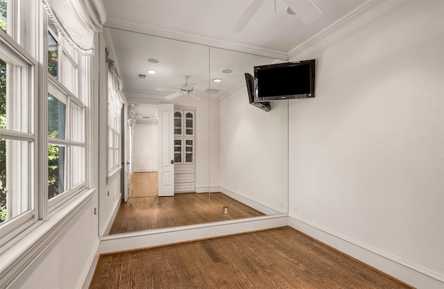 interior space with plenty of natural light, ornamental molding, dark hardwood / wood-style floors, and ceiling fan