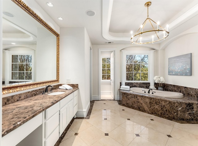 bathroom with vanity, tiled bath, a notable chandelier, and a tray ceiling