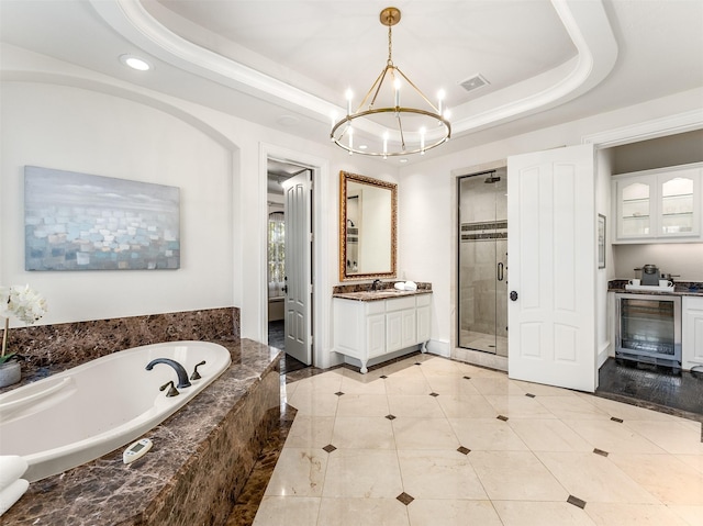 bathroom with vanity, beverage cooler, a raised ceiling, a notable chandelier, and plus walk in shower