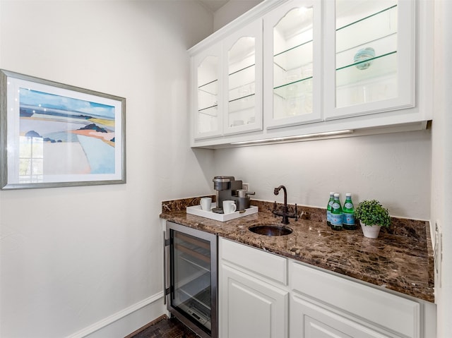 bar with white cabinetry, sink, dark stone countertops, and wine cooler