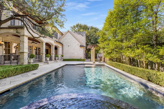 view of swimming pool with ceiling fan and a patio area