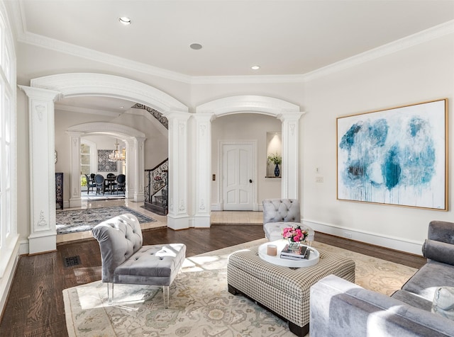 living room with ornate columns, crown molding, and hardwood / wood-style flooring