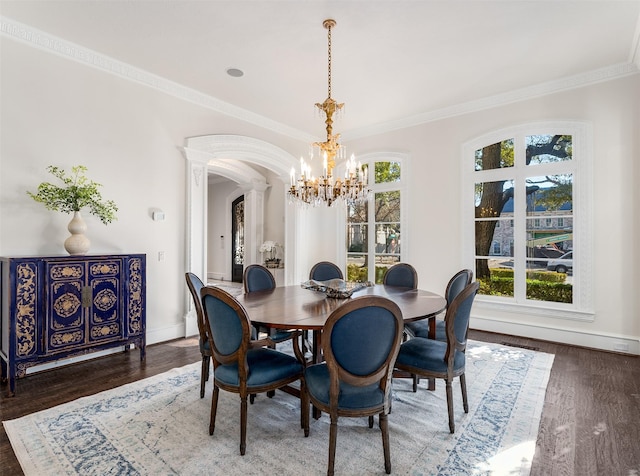 dining space featuring dark hardwood / wood-style flooring, ornamental molding, and a chandelier